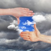 Collage with hands and blue cloudy sky