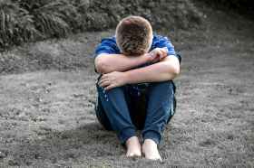 rear view of a boy sitting on grassland