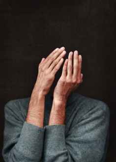 person in gray sweater cover face